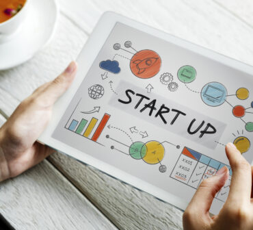 Tablet screen showing a colorful startup concept with charts, graphs, and business icons, symbolizing innovation and growth.